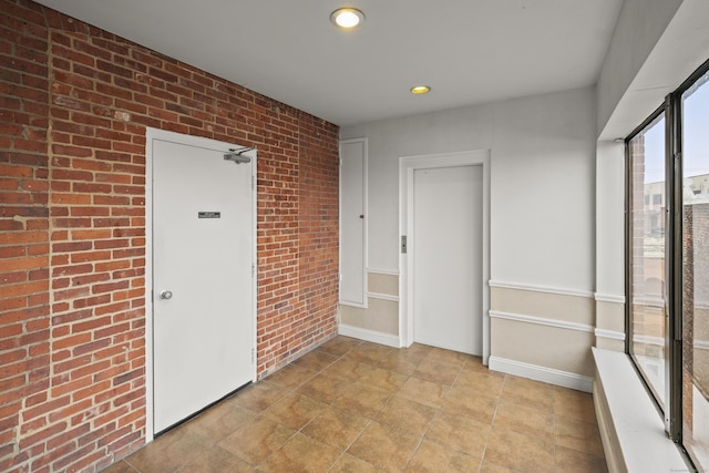 interior space with recessed lighting, baseboards, and brick wall