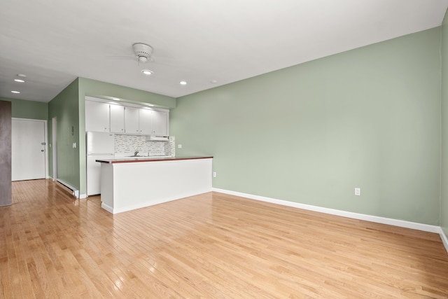 unfurnished living room with recessed lighting, light wood-type flooring, and baseboards