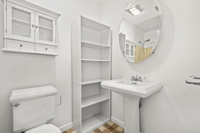 bathroom featuring a sink, baseboards, and toilet