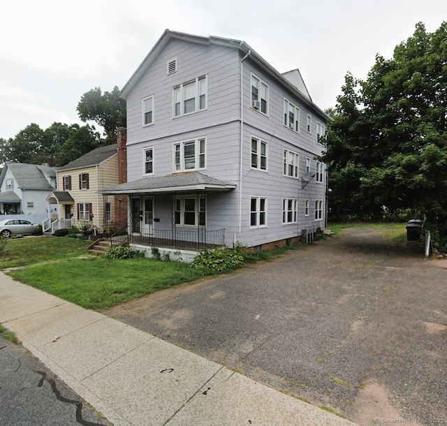 view of front of property featuring covered porch and a front yard