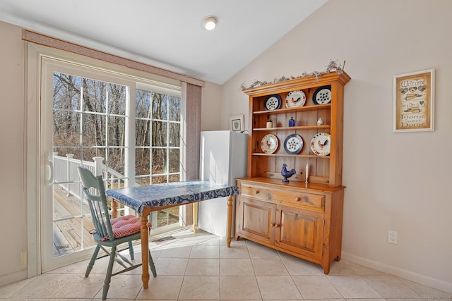 living area with light tile patterned floors, baseboards, and vaulted ceiling