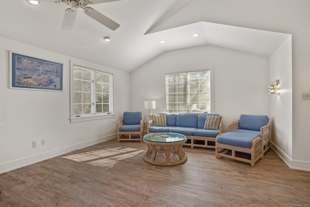 living area with a wealth of natural light, wood finished floors, and vaulted ceiling