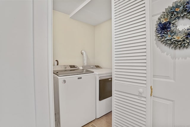 laundry area with light tile patterned flooring and washer and clothes dryer