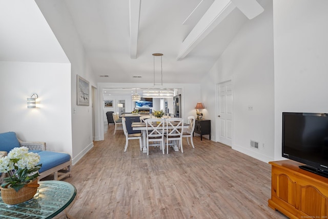 dining area featuring visible vents, baseboards, lofted ceiling with beams, and light wood-style floors