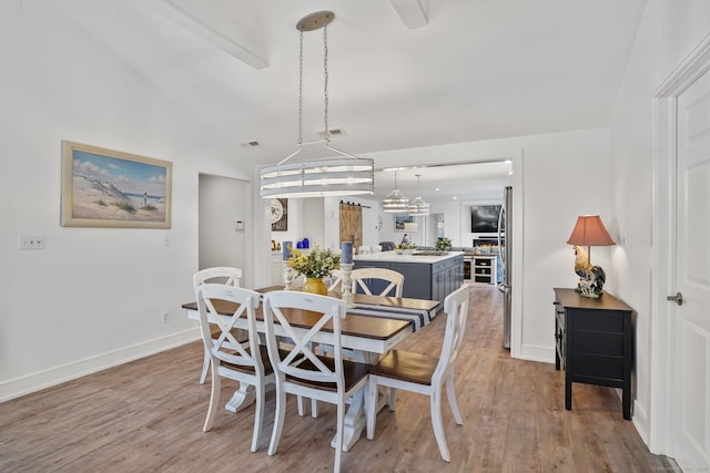 dining room featuring visible vents, baseboards, and wood finished floors