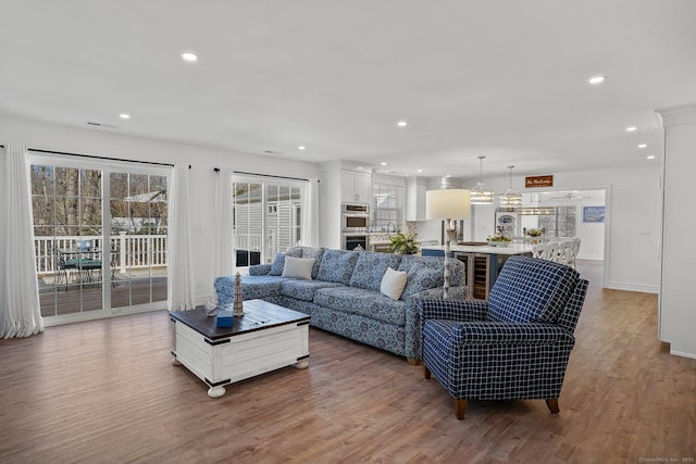 living room featuring visible vents, recessed lighting, baseboards, and light wood-style floors