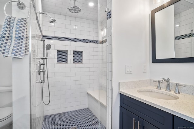 full bathroom with a stall shower, toilet, and vanity