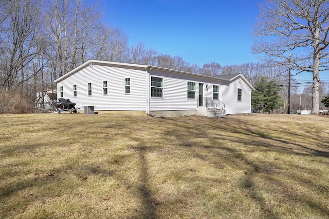 back of property with cooling unit and a lawn