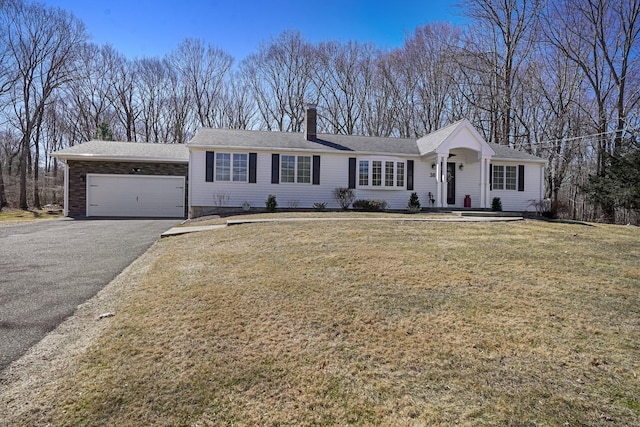 ranch-style house with aphalt driveway, an attached garage, a chimney, and a front lawn