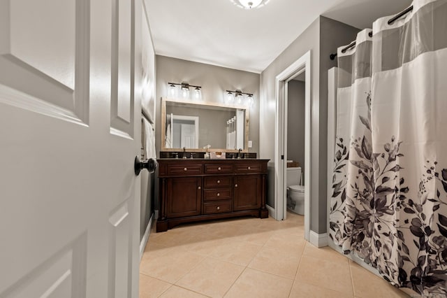 full bathroom featuring tile patterned floors, toilet, double vanity, and a sink