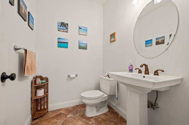 bathroom with toilet and baseboards