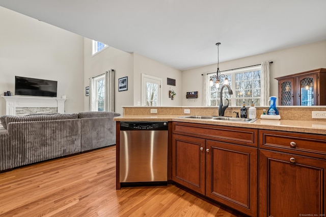 kitchen featuring a sink, light wood-style floors, dishwasher, and light countertops