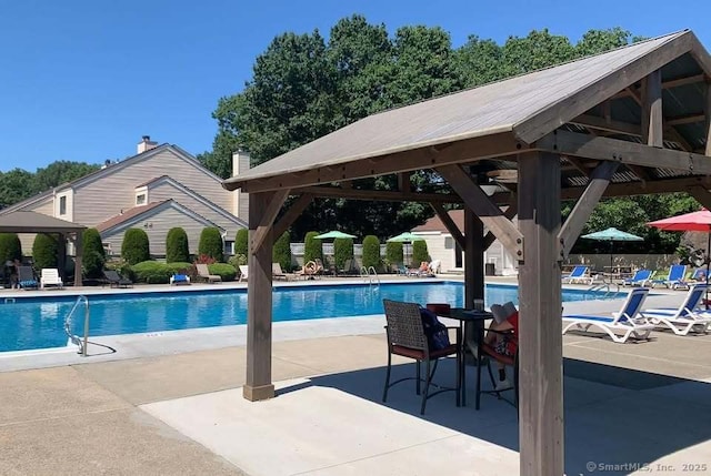 community pool with a gazebo, a patio, and fence