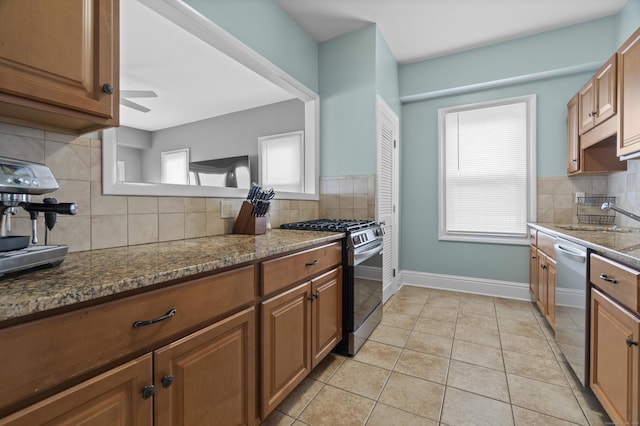 kitchen with stainless steel appliances, tasteful backsplash, brown cabinets, and a sink