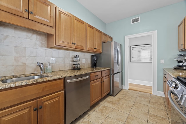 kitchen featuring light tile patterned floors, visible vents, a sink, stainless steel appliances, and tasteful backsplash