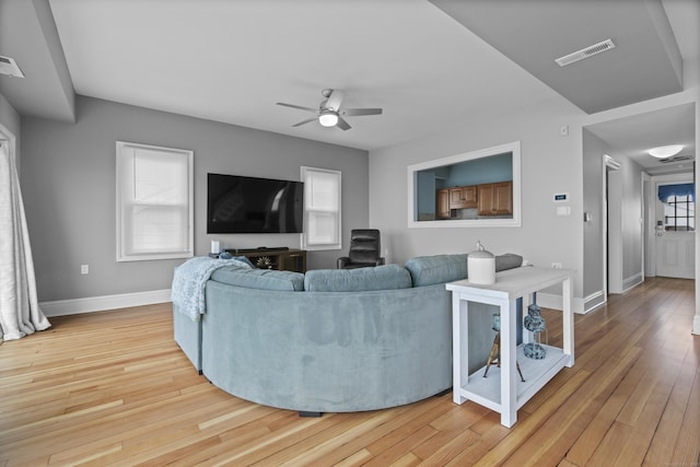 living area featuring ceiling fan, hardwood / wood-style flooring, baseboards, and visible vents