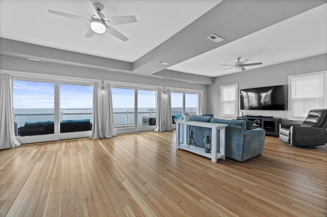 living area featuring ceiling fan, light wood-type flooring, and visible vents