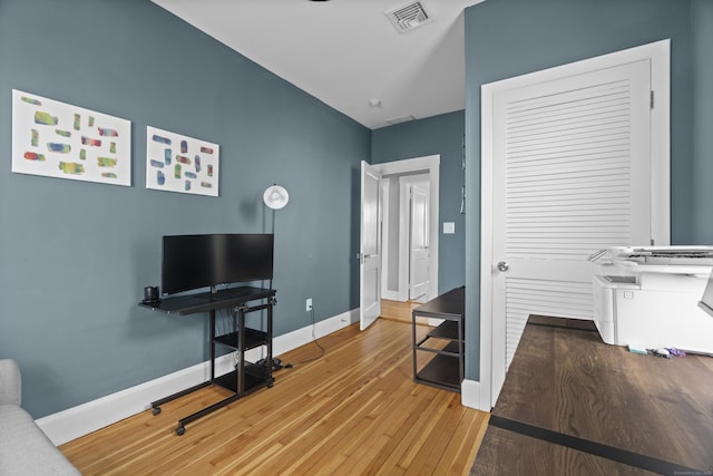 living room with visible vents, baseboards, and wood-type flooring