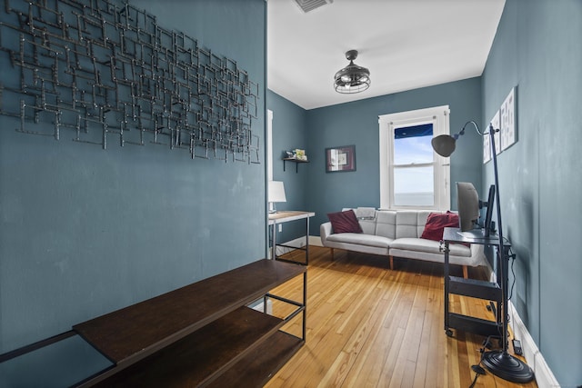 living area with wood-type flooring, baseboards, and visible vents