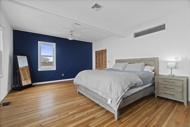bedroom featuring baseboards, ceiling fan, light wood-style flooring, and visible vents