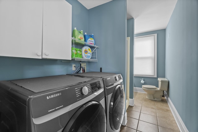clothes washing area with washer and dryer, cabinet space, tile patterned flooring, and baseboards