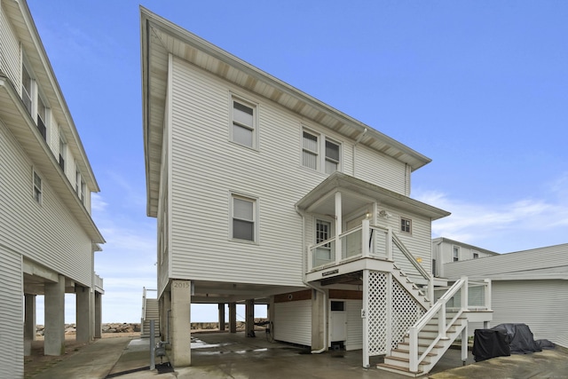 rear view of house with stairway and a carport