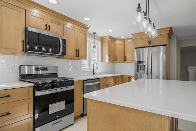 kitchen with pendant lighting, tasteful backsplash, appliances with stainless steel finishes, and light countertops