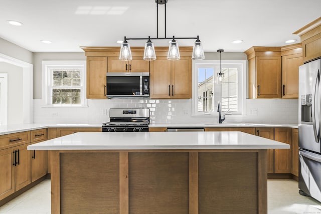 kitchen featuring light tile patterned floors, stainless steel appliances, light countertops, and a sink