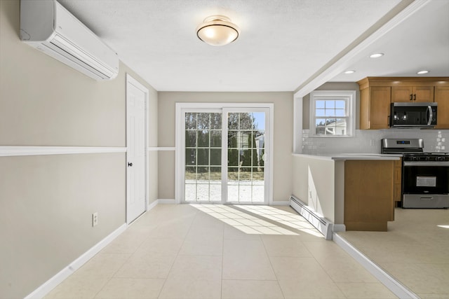 kitchen with brown cabinets, an AC wall unit, a baseboard heating unit, backsplash, and stainless steel appliances