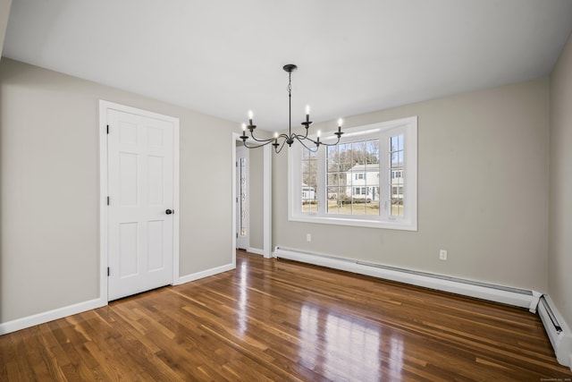 unfurnished dining area featuring a notable chandelier, baseboards, baseboard heating, and wood finished floors