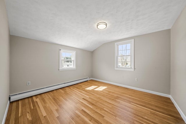 bonus room featuring lofted ceiling, a textured ceiling, hardwood / wood-style floors, baseboards, and baseboard heating