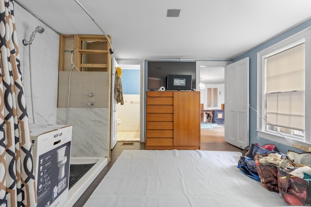 interior space featuring connected bathroom, visible vents, and wood finished floors