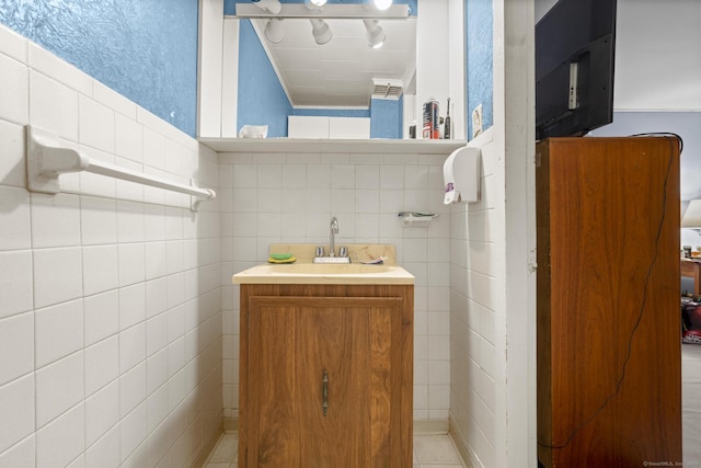 half bath with tile walls and vanity