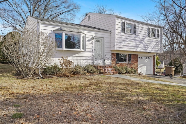 tri-level home with aphalt driveway, brick siding, and an attached garage