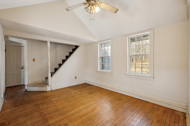 unfurnished living room with a ceiling fan, baseboards, stairs, vaulted ceiling, and wood-type flooring