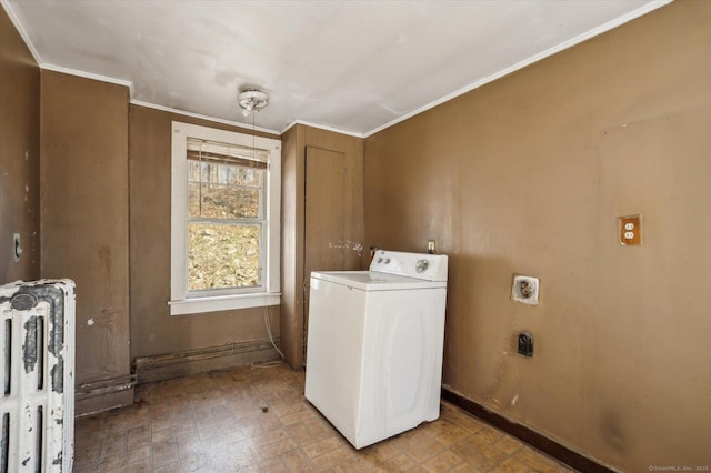 clothes washing area featuring ornamental molding, radiator, baseboards, washer / dryer, and laundry area