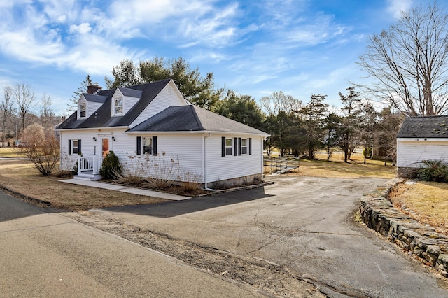 view of front facade with aphalt driveway and a chimney