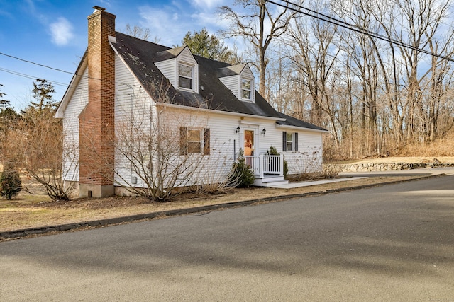 cape cod home featuring a chimney