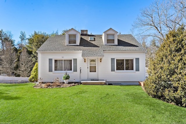 cape cod home with a chimney, fence, a front yard, and roof with shingles