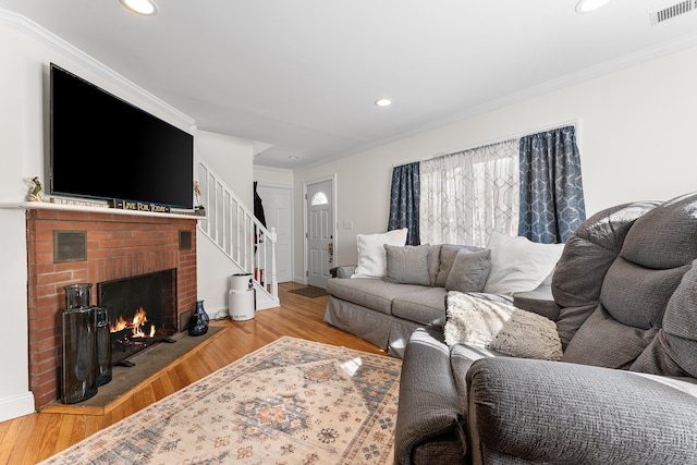 living room with crown molding, wood finished floors, and visible vents