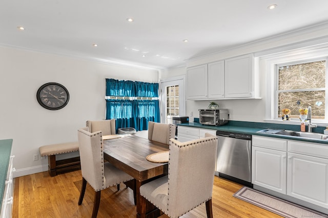 dining space featuring baseboards, crown molding, and light wood-style floors