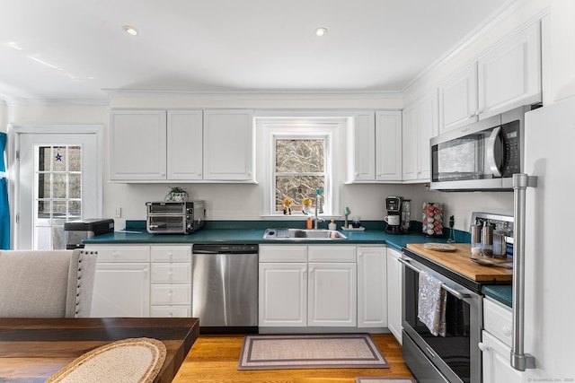 kitchen featuring a sink, white cabinets, and stainless steel appliances