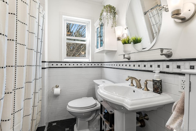 bathroom featuring a shower with curtain, toilet, and tile walls