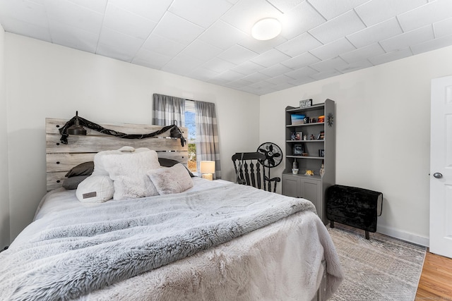 bedroom featuring baseboards and wood finished floors