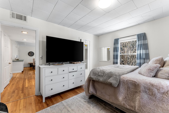 bedroom featuring light wood-style floors and visible vents