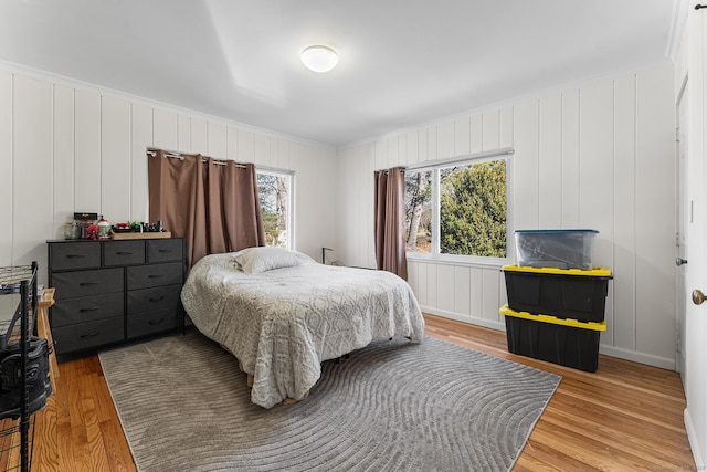 bedroom with light wood-style floors and ornamental molding