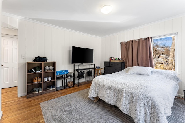 bedroom with light wood-style floors and ornamental molding