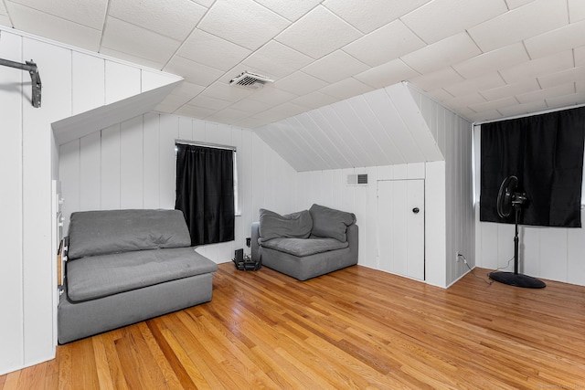 sitting room with light wood finished floors, visible vents, and vaulted ceiling