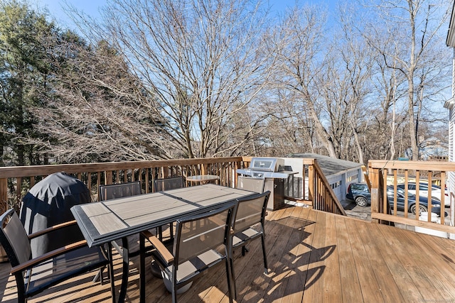 wooden terrace featuring outdoor dining area and a grill