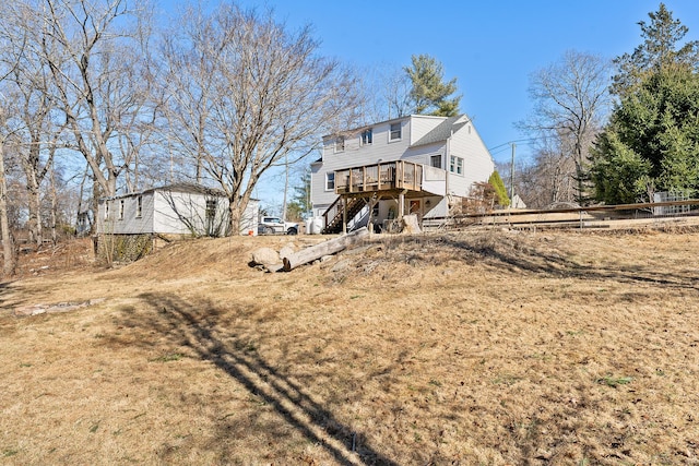 rear view of property with stairway, a deck, and fence